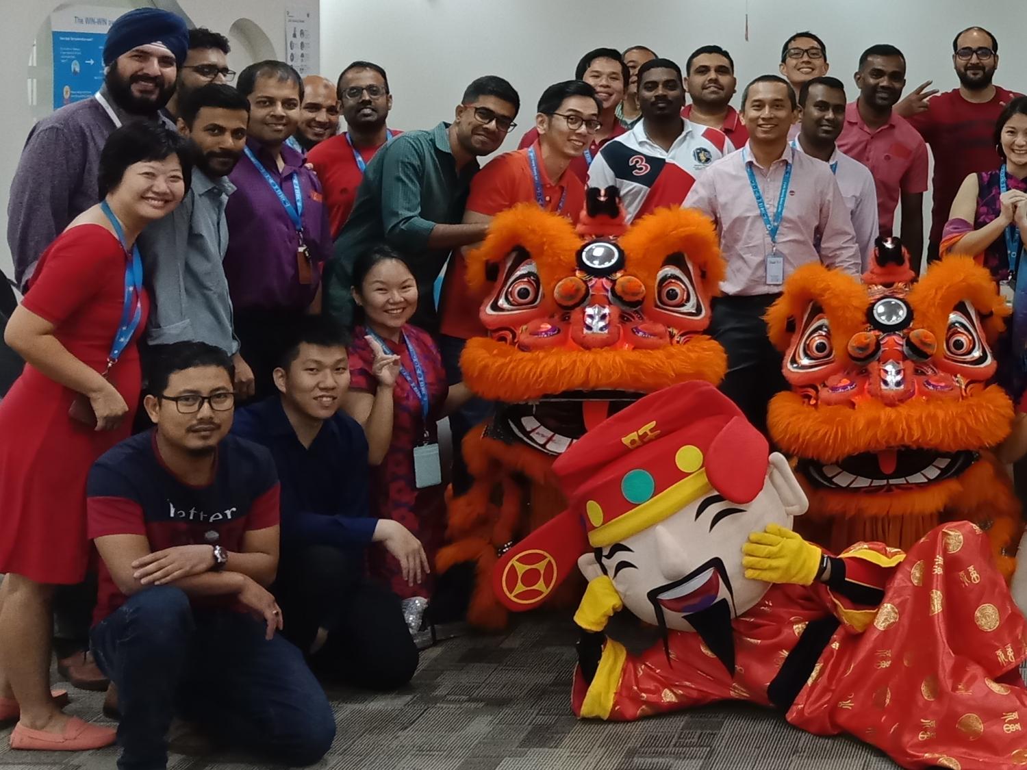 Group of people posing for the camera with two dressed up dragons
