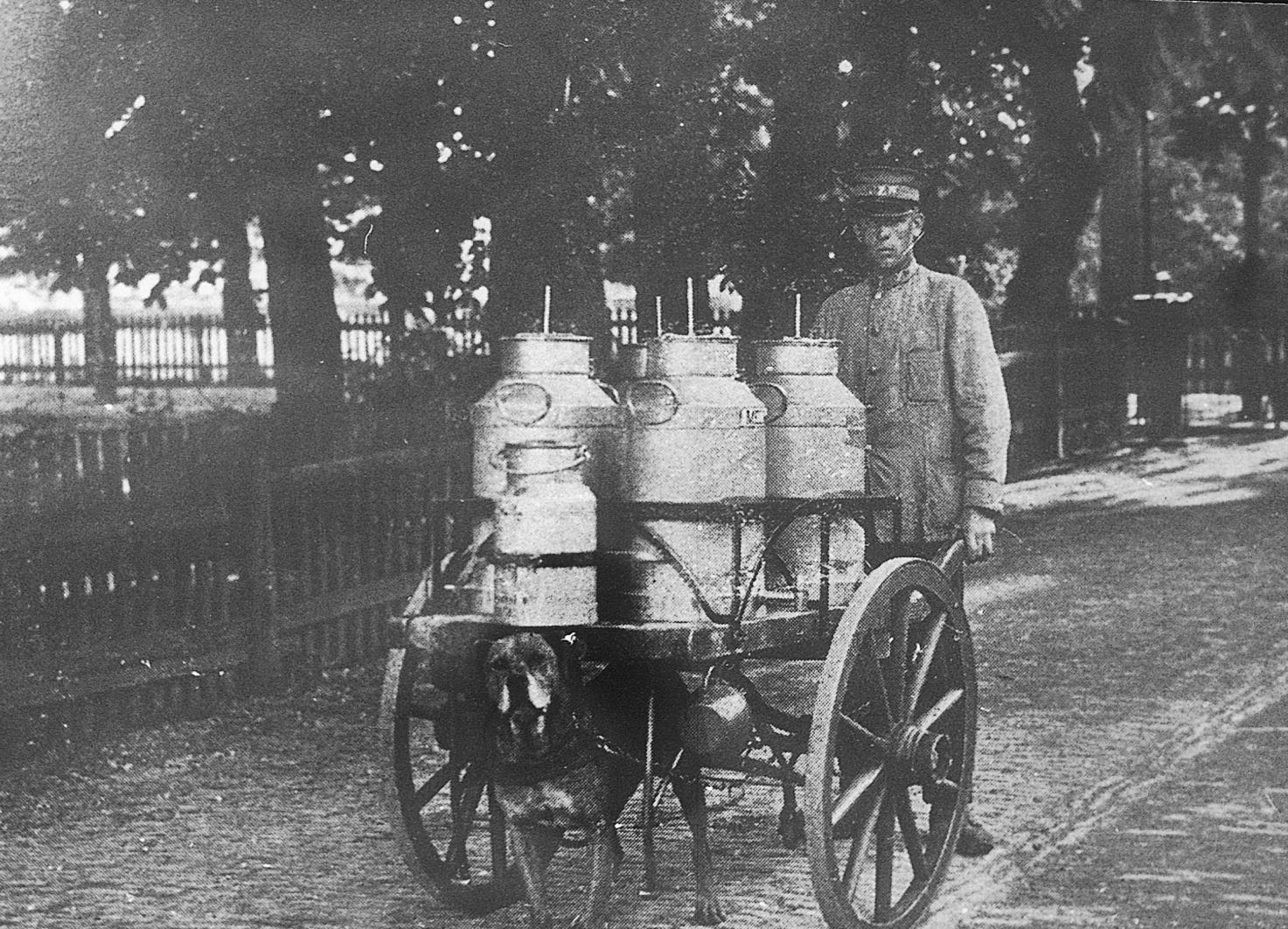 Image of a farmer pushing a cart of milk