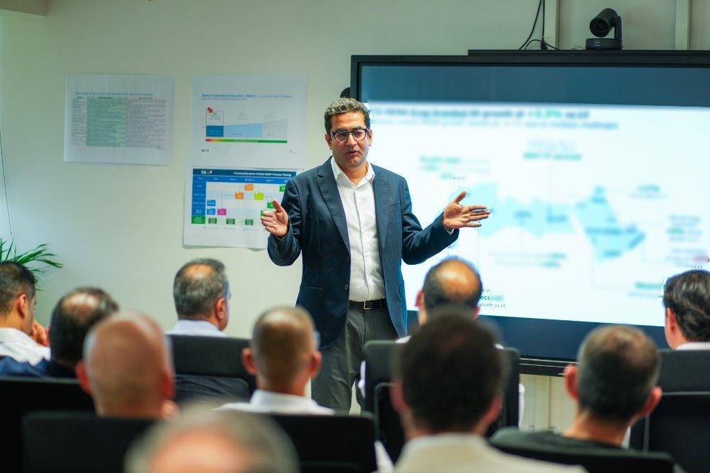 A person standing in front of a large screen__Description automatically generated.jpg
